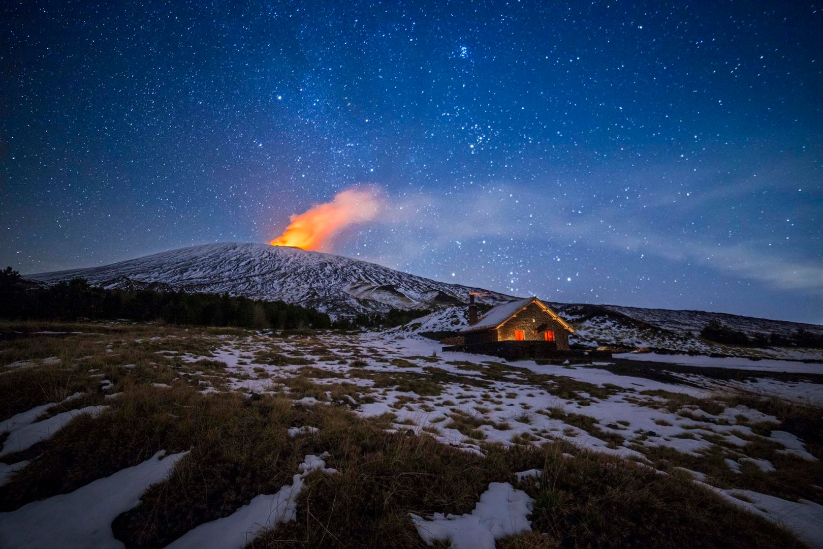 Rifugio Galvarina durante una notte di cielo stellato e un eruzione