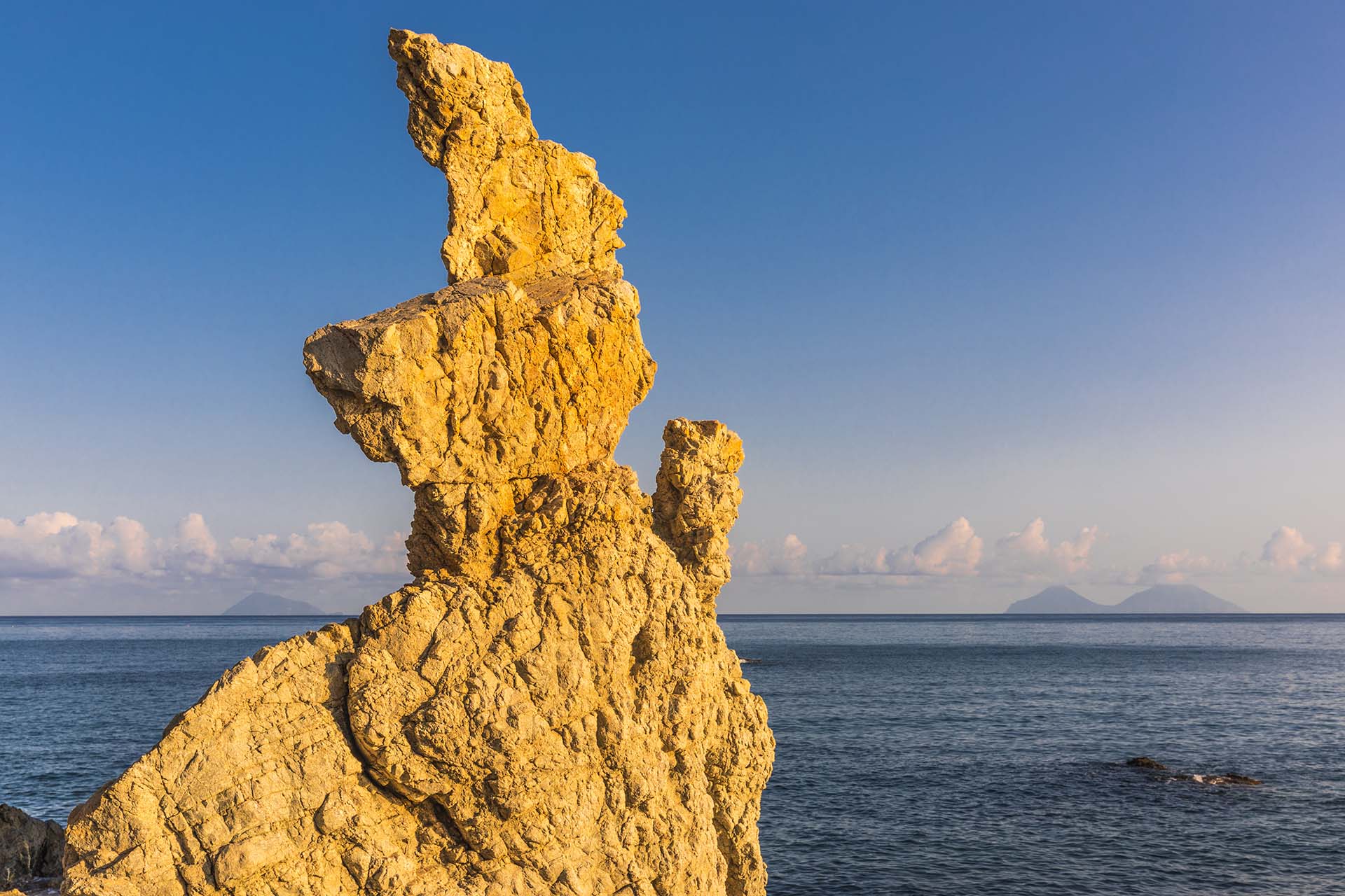 Capo d'Orlando, le sculture nella roccia di San Gregorio con dietro le Isole Eolie.