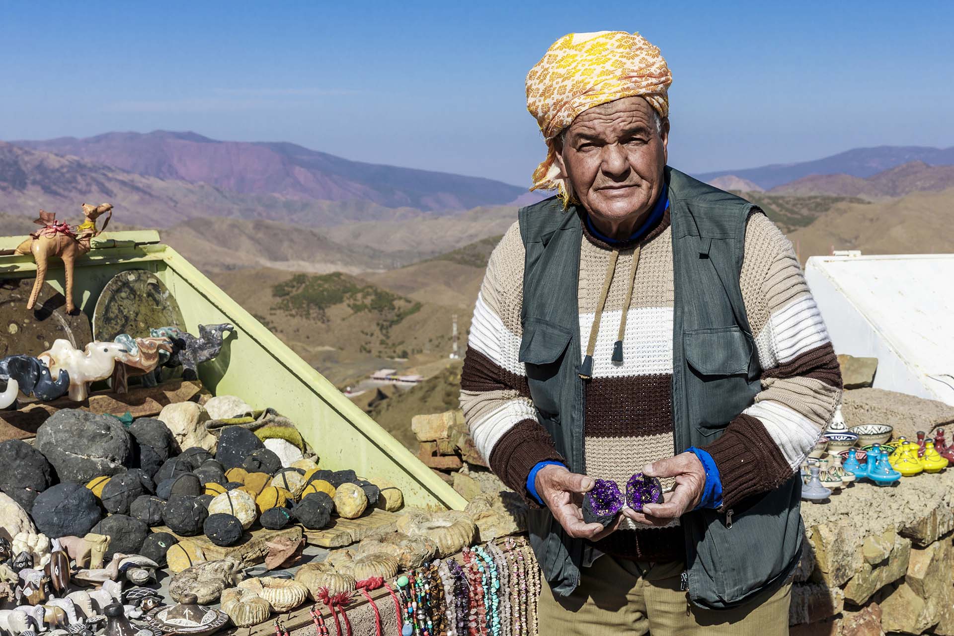 Marocco, venditore di souvenir tradizionali e fossili minerali nelle montagne dell'Alto Attlante
