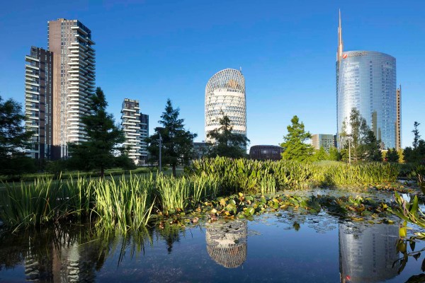 Le torri Unicredit e UnipolSai riflesse nello specchio d'acqua del parco "La Biblioteca degli Alberi" a Milano.