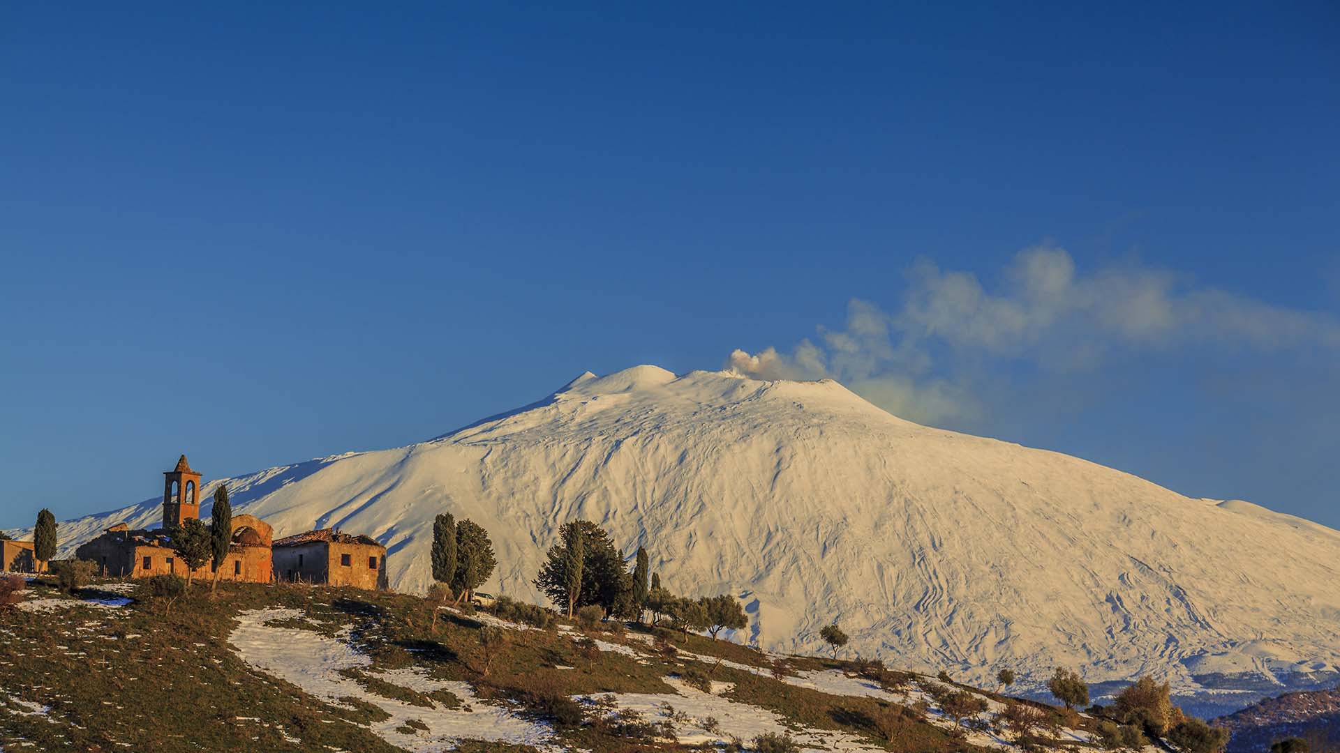 Borgo Giuliano con vista dell'Etna vestita di bianco