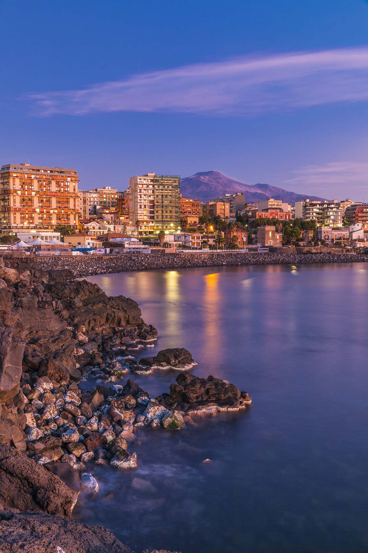 Catania, la costa lavica di piazza Europa con l'Etna sullo sfondo
