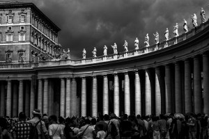 Roma, il colonnato di piazza San Pietro con le statue degli Angeli illuminati da un raggio di luce