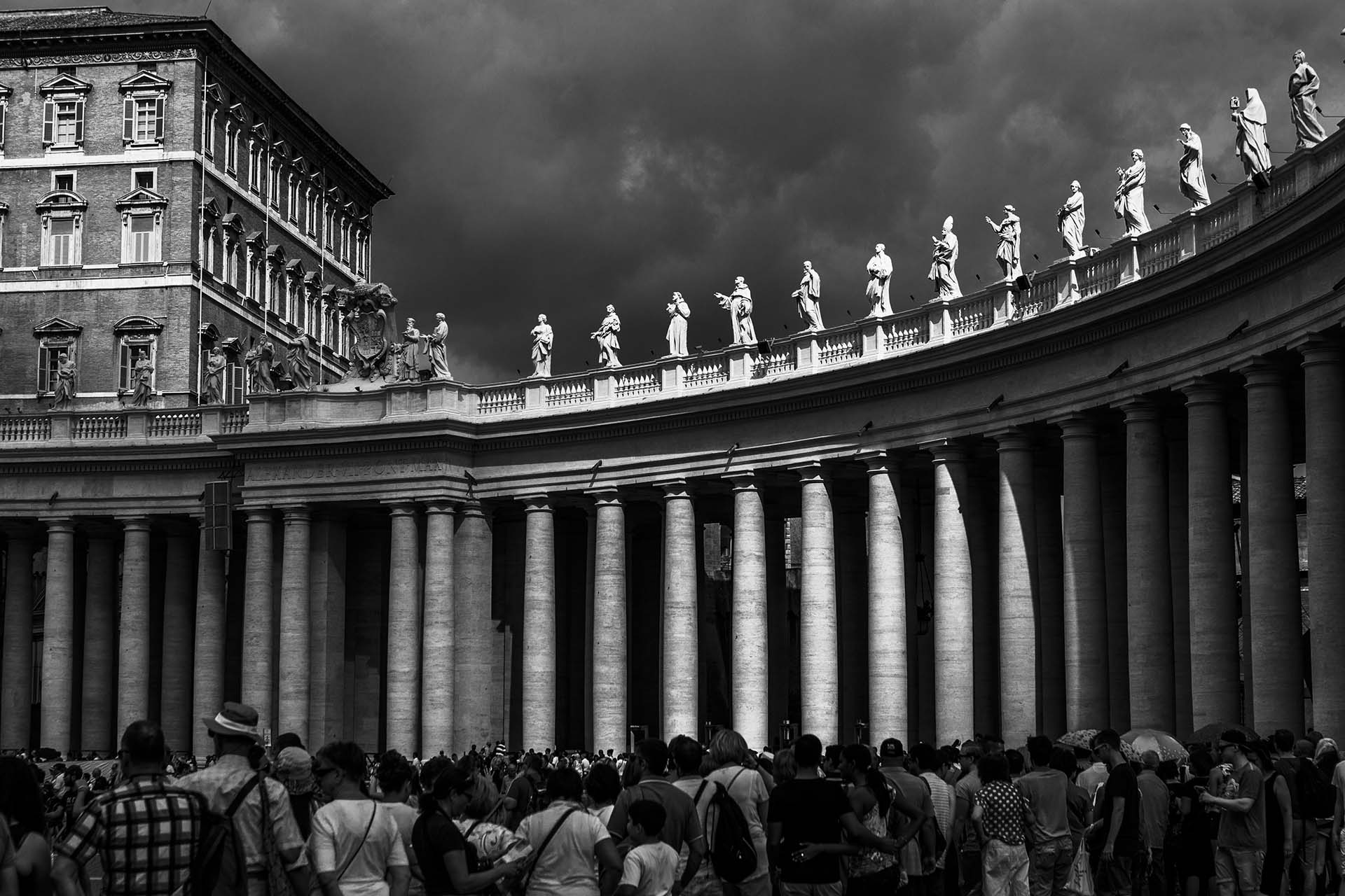 Roma, il colonnato di piazza San Pietro con le statue degli Angeli illuminati da un raggio di luce