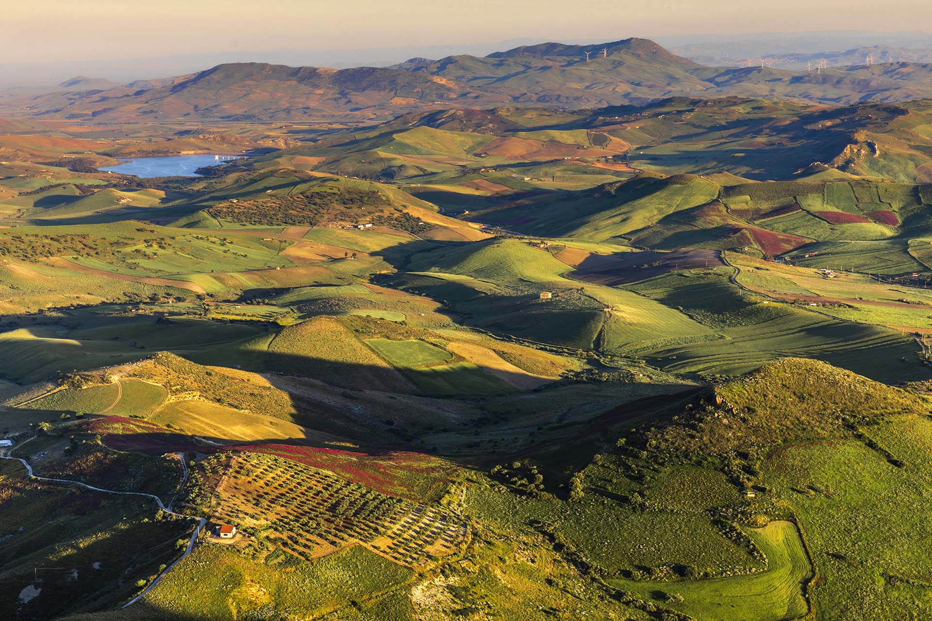 SAFF7084-Enna, le colline di grano verde e il lago Sciaguana nel territorio di Agira