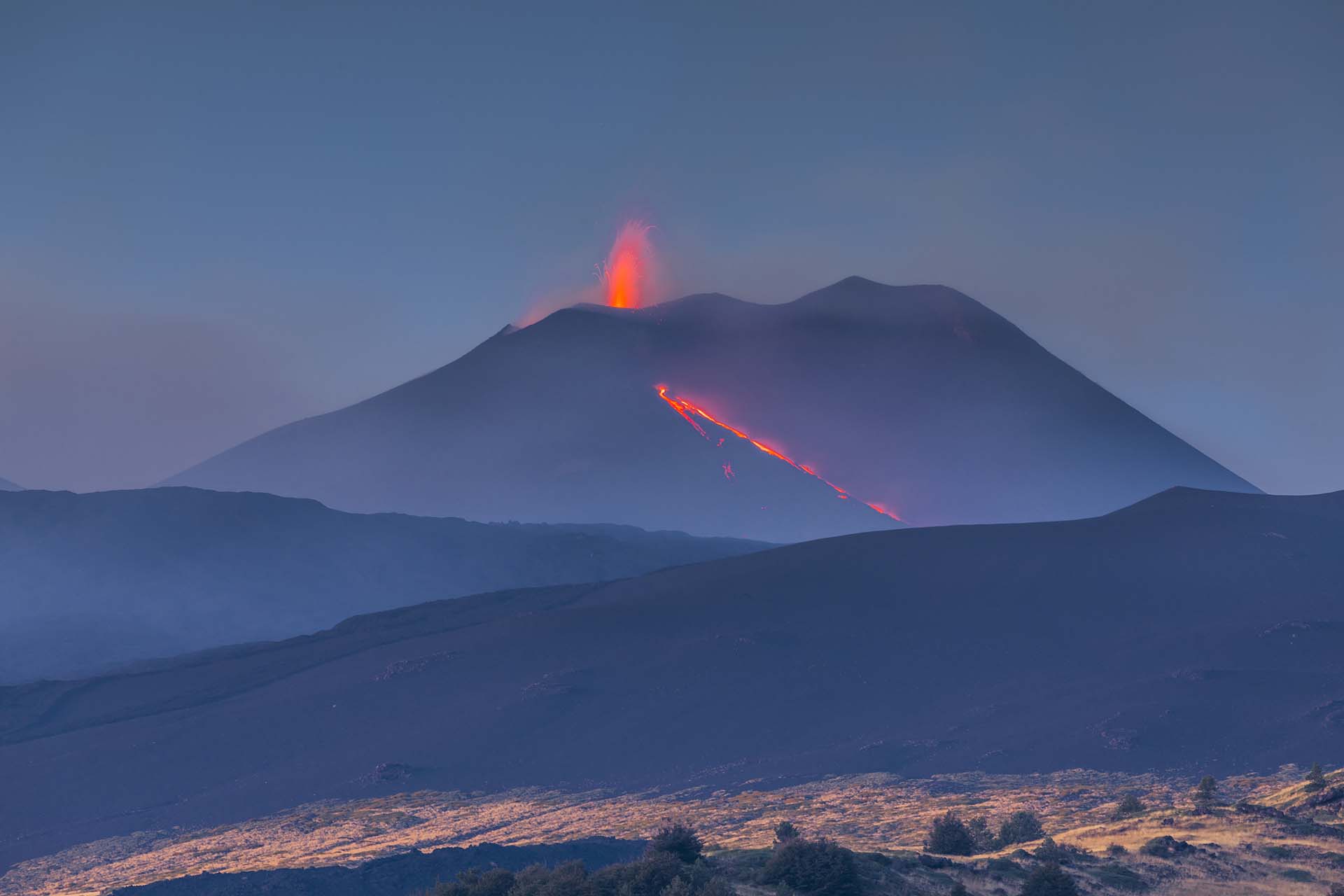 SAFF1944-Etna, eruzione dal cratere centrale con un fiume di lava tra paesaggio lunare e vegetazione