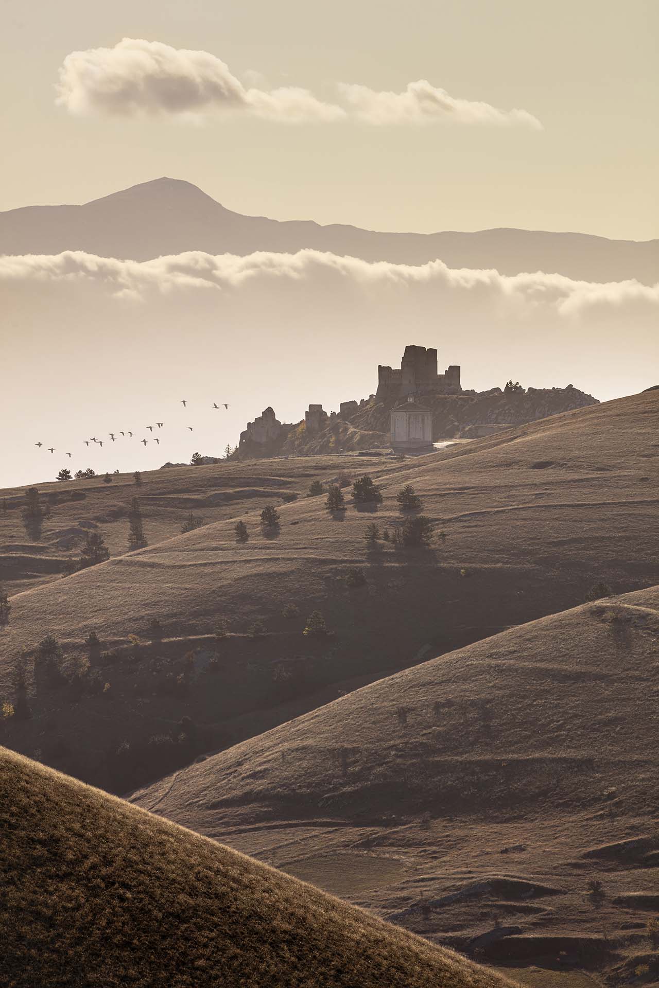Il castello normanno di Rocca Calascio e la chiesa di Santa Maria della Pietà nel paesaggio del Parco nazionale del Gran Sasso e Monti della Laga.