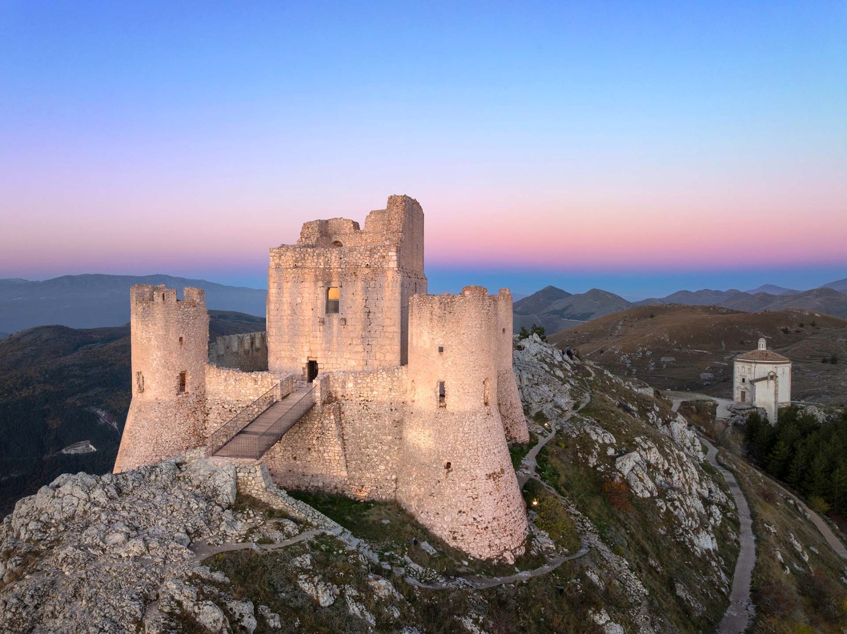 Il castello normanno di Rocca Calascio e la chiesa di Santa Maria della Pietà nel paesaggio del Parco nazionale del Gran Sasso e Monti della Laga.