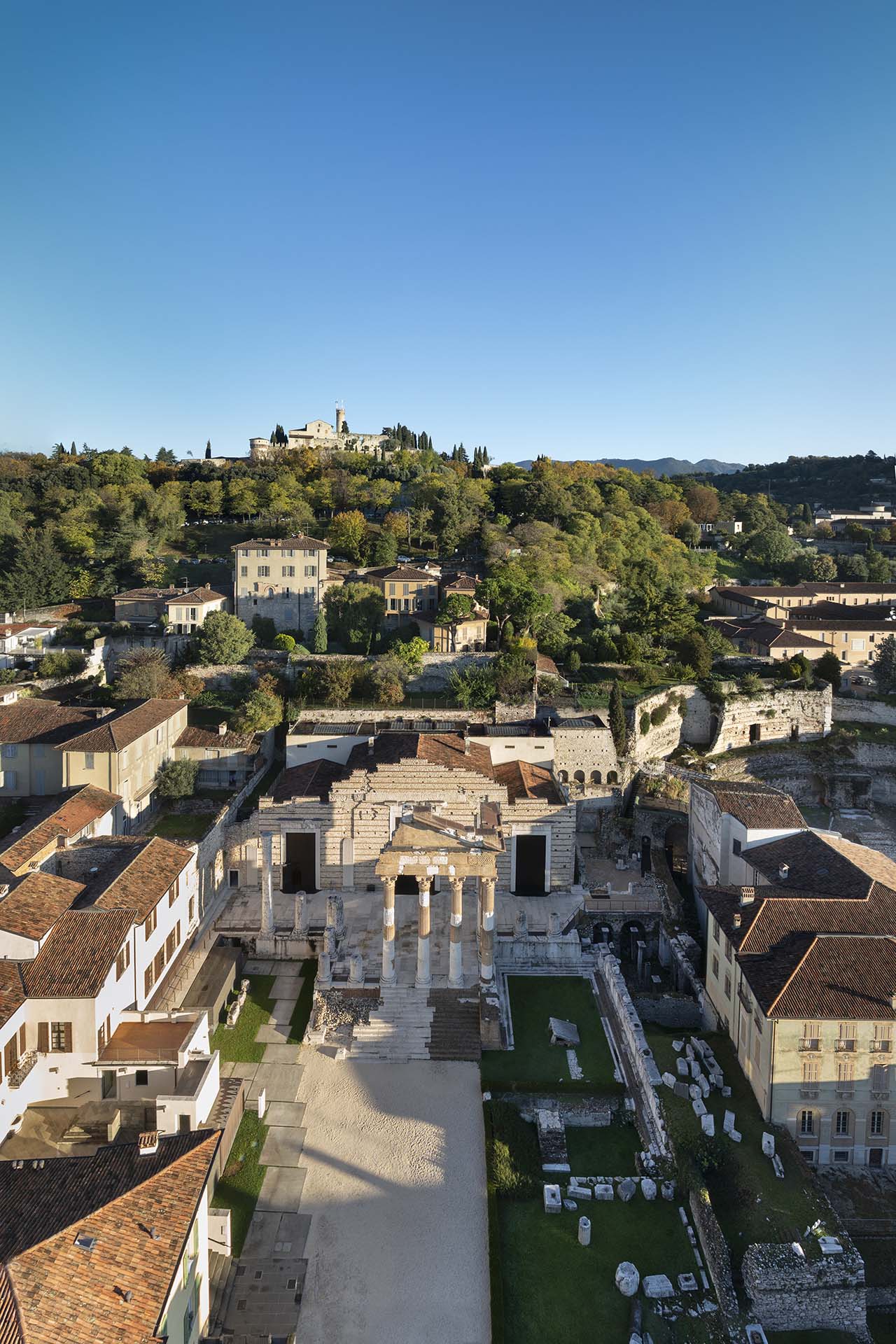 Il Capitolium o Tempio Capitolino situato a Brescia in Piazza del Foro e dietro il Colle Cidneo con il Castello.