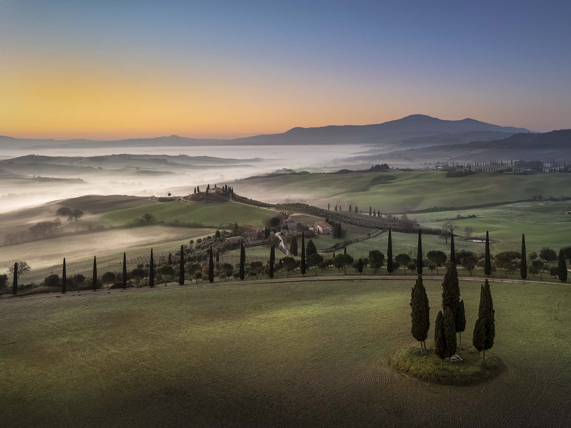 Il paesaggio della Val d’Orcia tra nebbie, cipressi e il Monte Amiata.