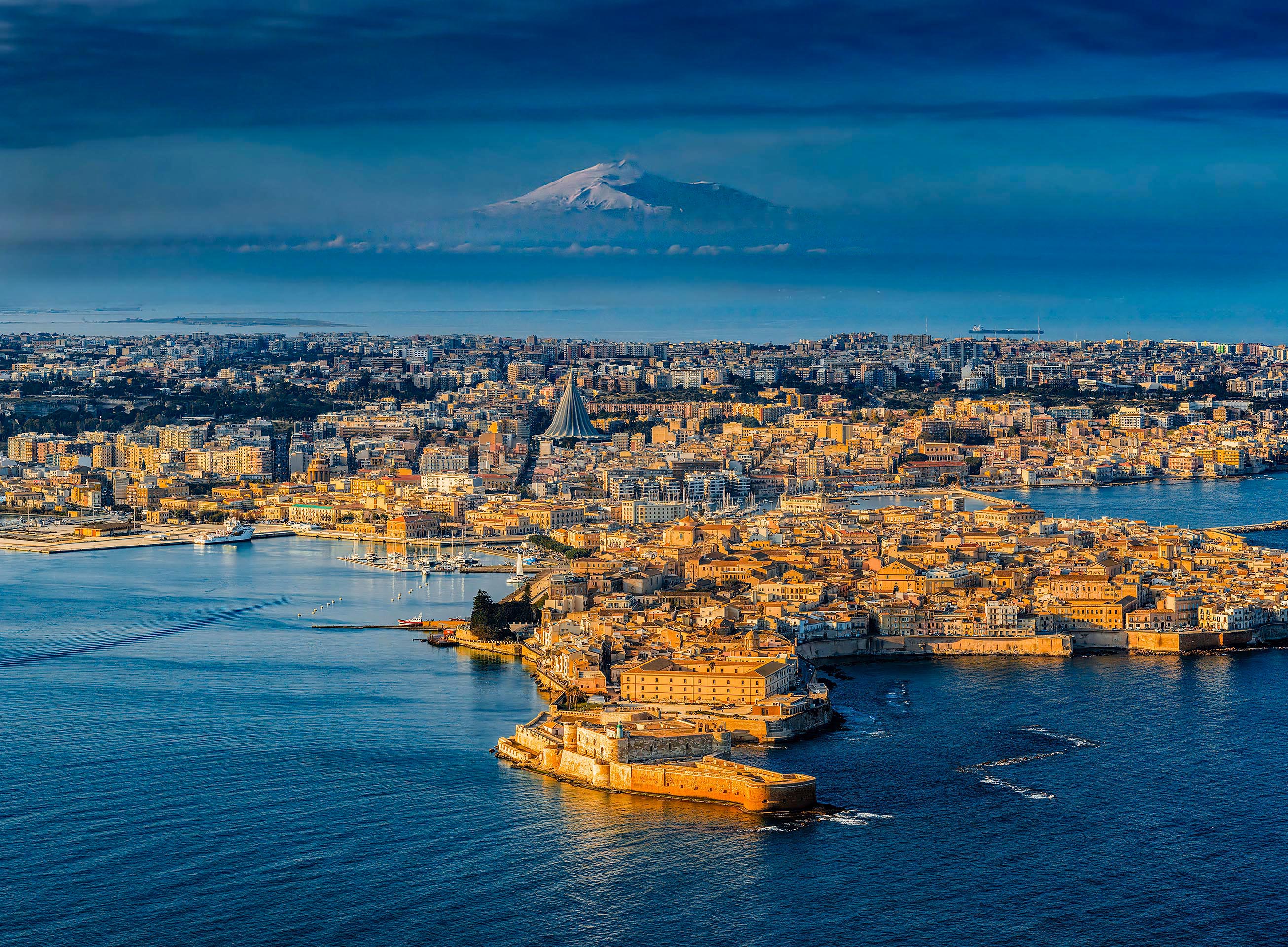 Siracusa: Veduta aerea di Ortigia e del Castello Maniace con l’Etna innevato