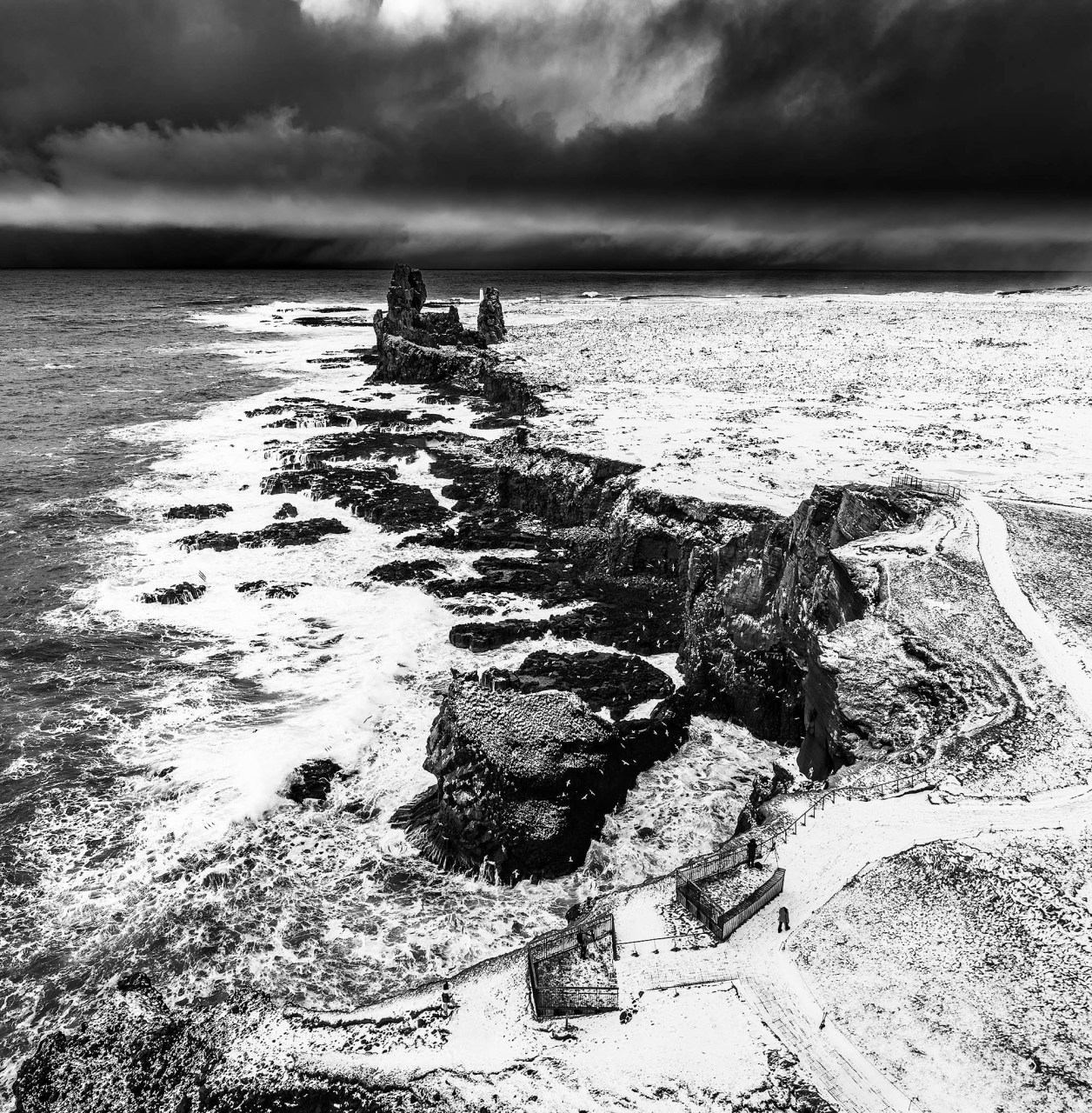 Fotografia professionale in bianco e nero dei Lóndrangar in Islanda, picchi vulcanici di basalto sulla costa di Snæfellsnes durante l'inverno.