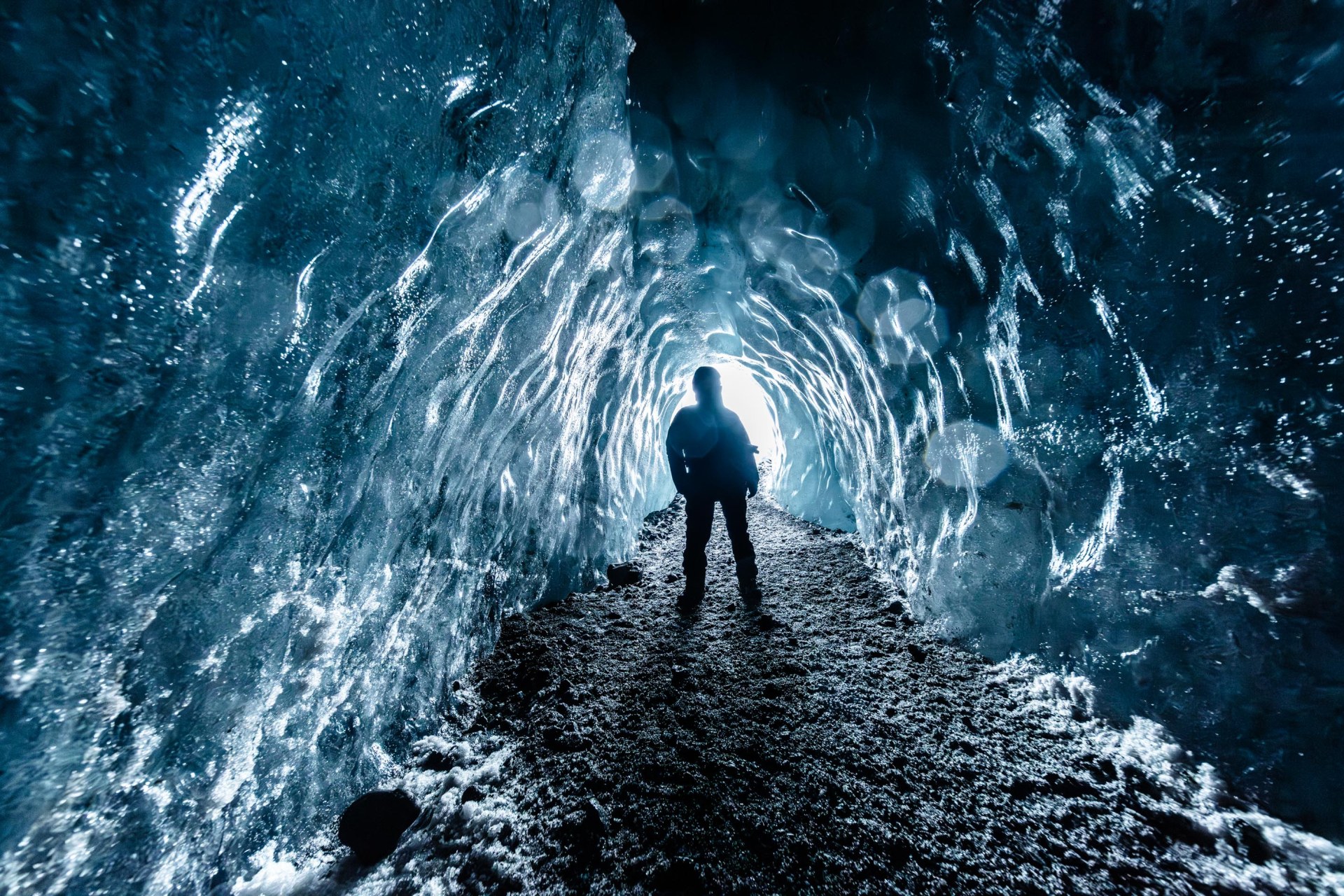 Esploratore in una grotta di ghiaccio blu sotto il Vatnajökull in Islanda.