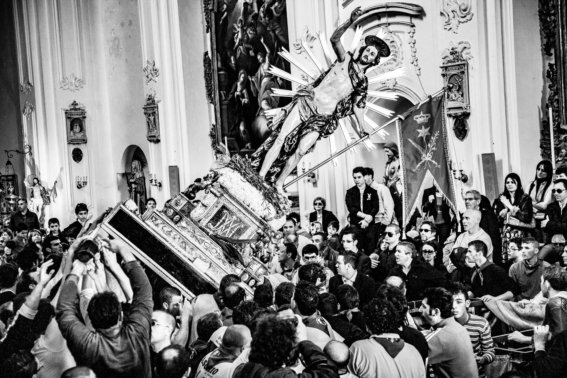 Fotografia in bianco e nero della statua dell'Uomo Vivo portata a spalla durante la Pasqua a Scicli