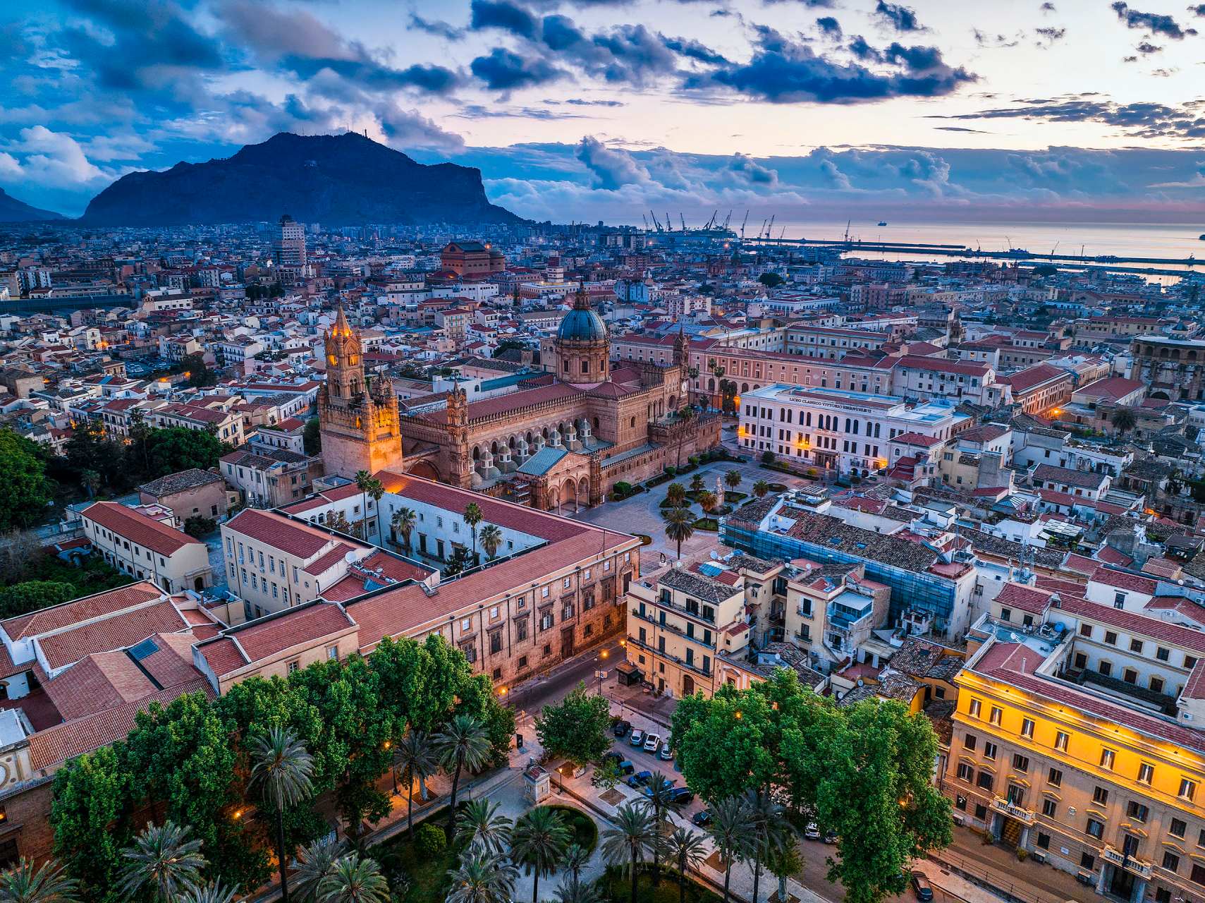 Veduta aerea della Cattedrale di Palermo al tramonto con mare e montagne sullo sfondo, fotografia professionale con drone