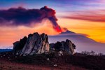 I megaliti dell'Altopiano dell'Argimusco in primo piano con l'Etna in eruzione al tramonto