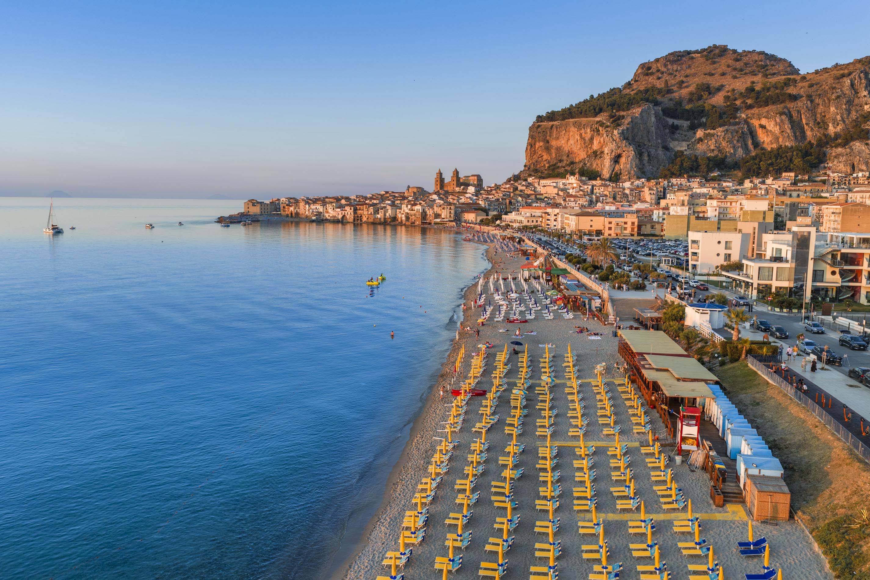 La Spiaggia di Cefalù al Tramonto: Un Abbraccio d’Oro tra Borgo, Mare e Rocca