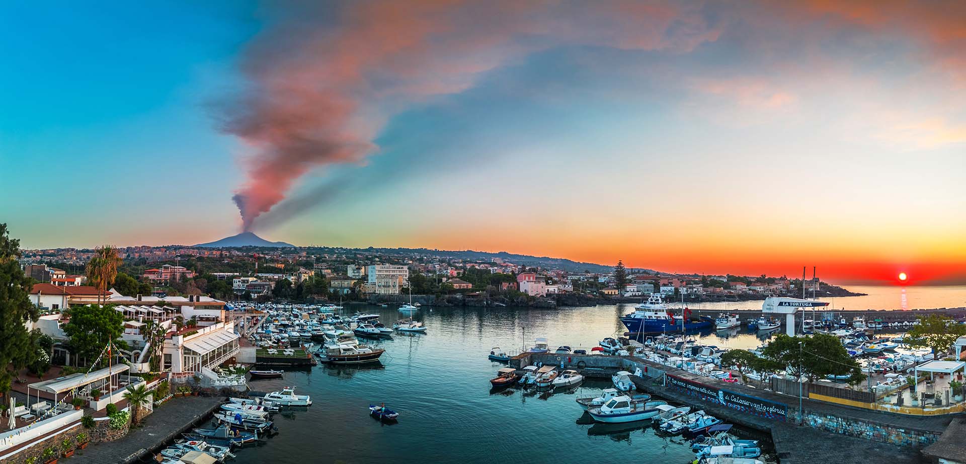 Il porticciolo di Ognina all’alba durante l’avvio di una nuova eruzione dell’Etna