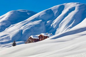 Baite alpine tradizionali coperte di neve fresca nella Val Federia a Livigno.