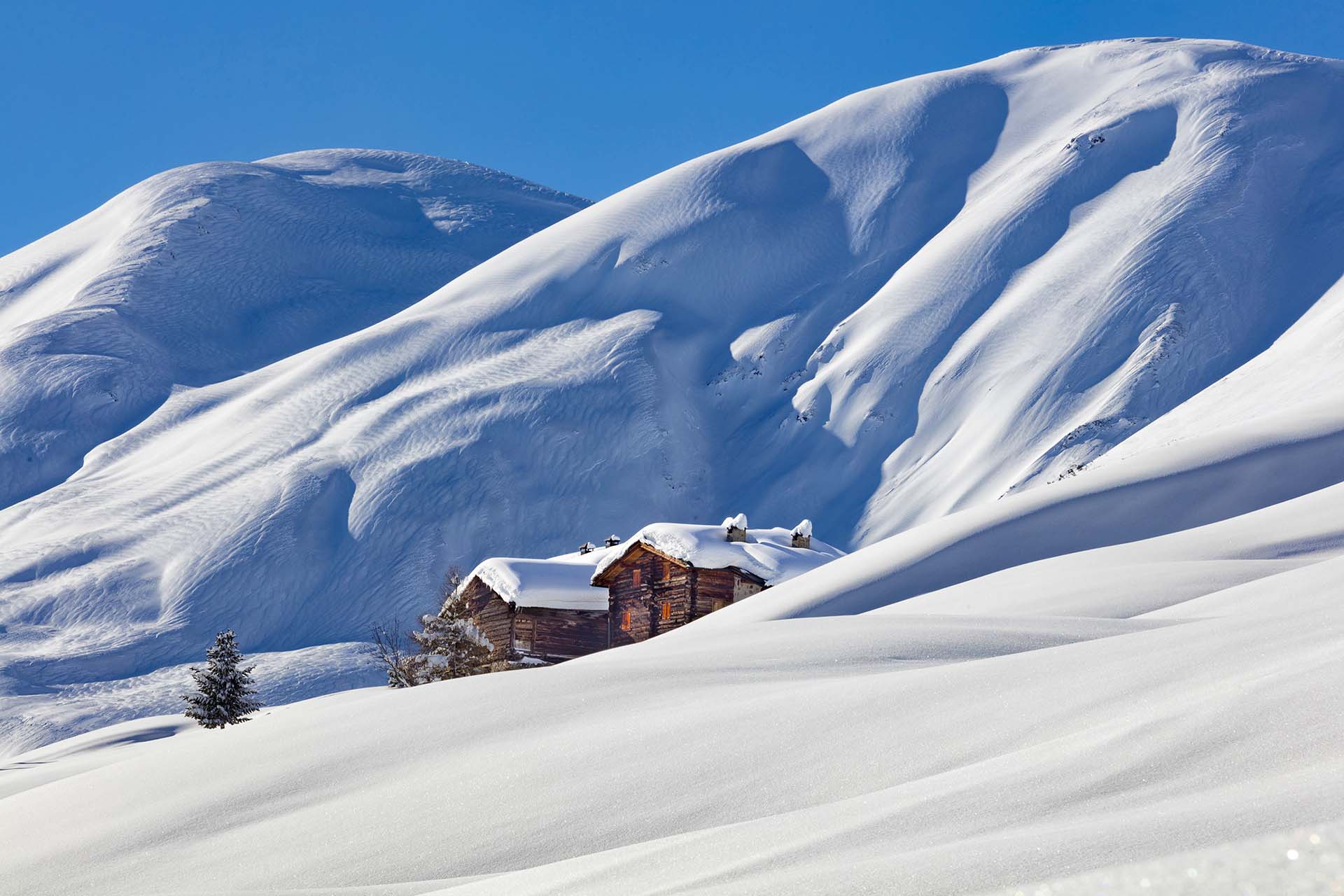 Baite alpine tradizionali coperte di neve fresca nella Val Federia a Livigno.