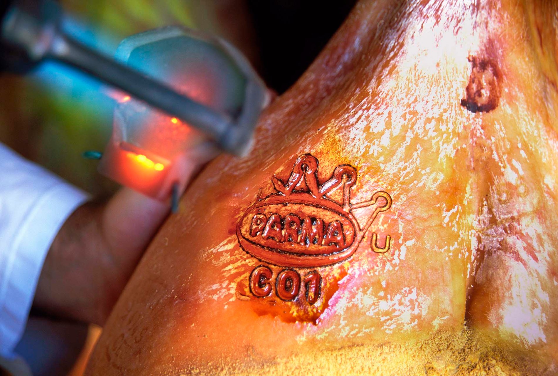 Momento in cui viene impresso a fuoco il celebre marchio a forma di corona ducale sulla coscia di un Prosciutto di Parma DOP