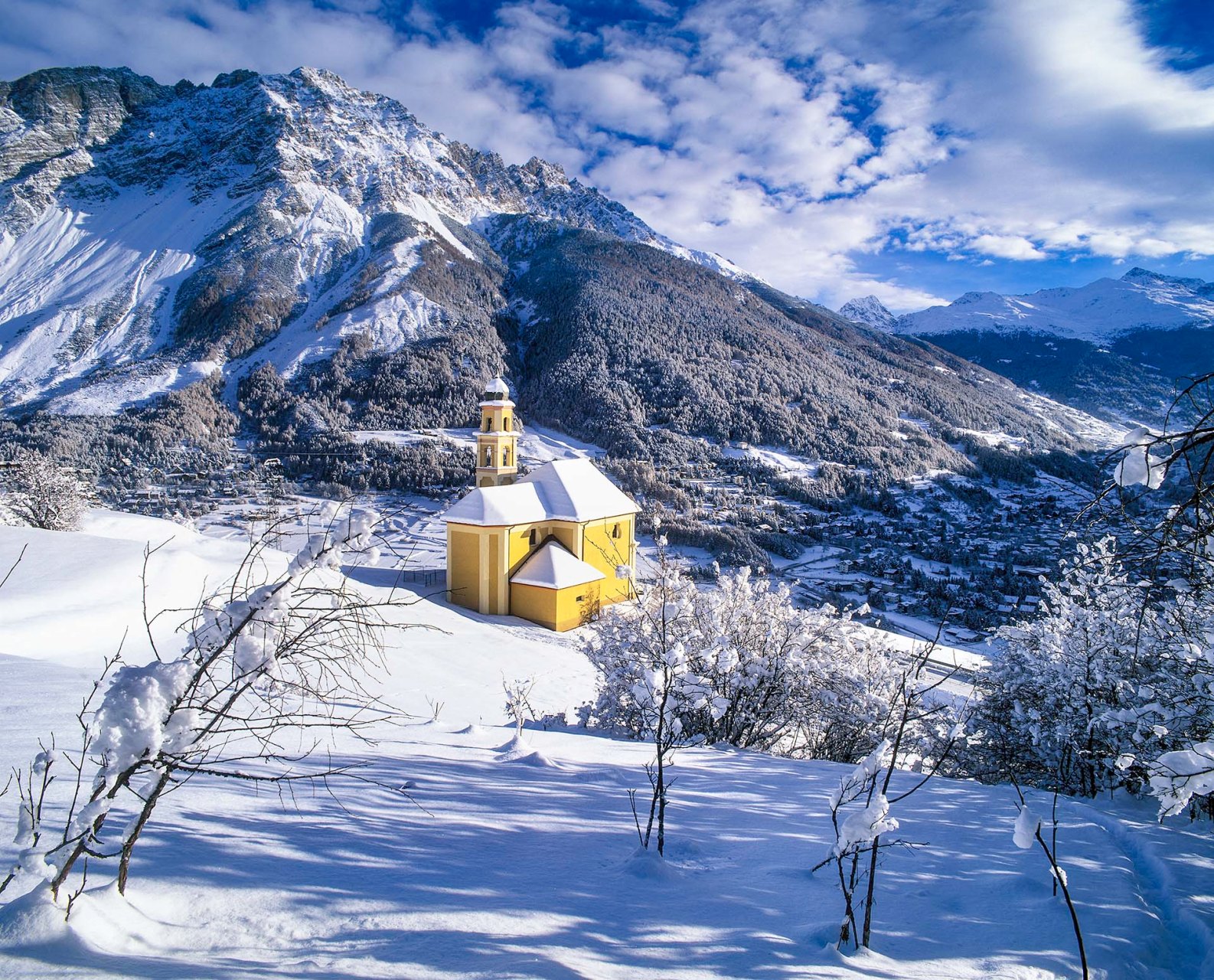 Vista sulla conca di Bormio con il santuario della Beata Vergine di Caravaggio a Oga.