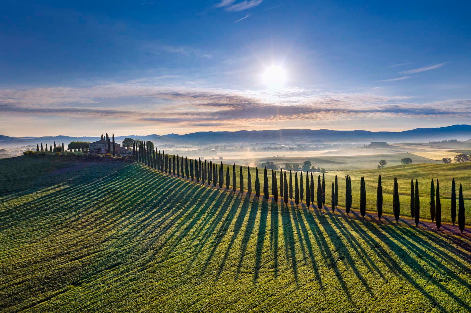Podere e cipressi tra le colline della Val d'Orcia in Toscana.