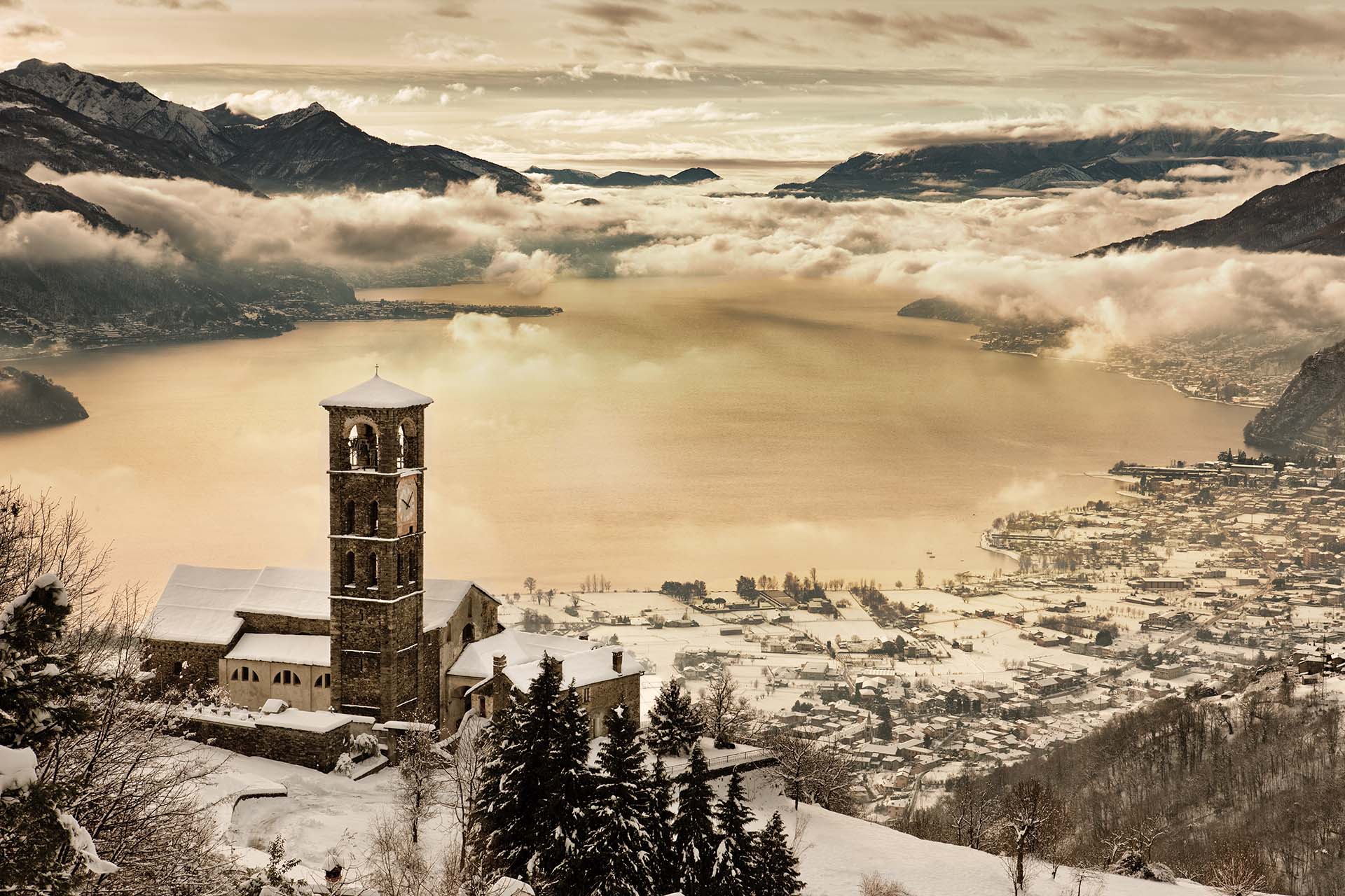 La chiesa di Sant'Eusebio a Peglio domina il Lago di Como appena imbiancato da una forte nevicata.