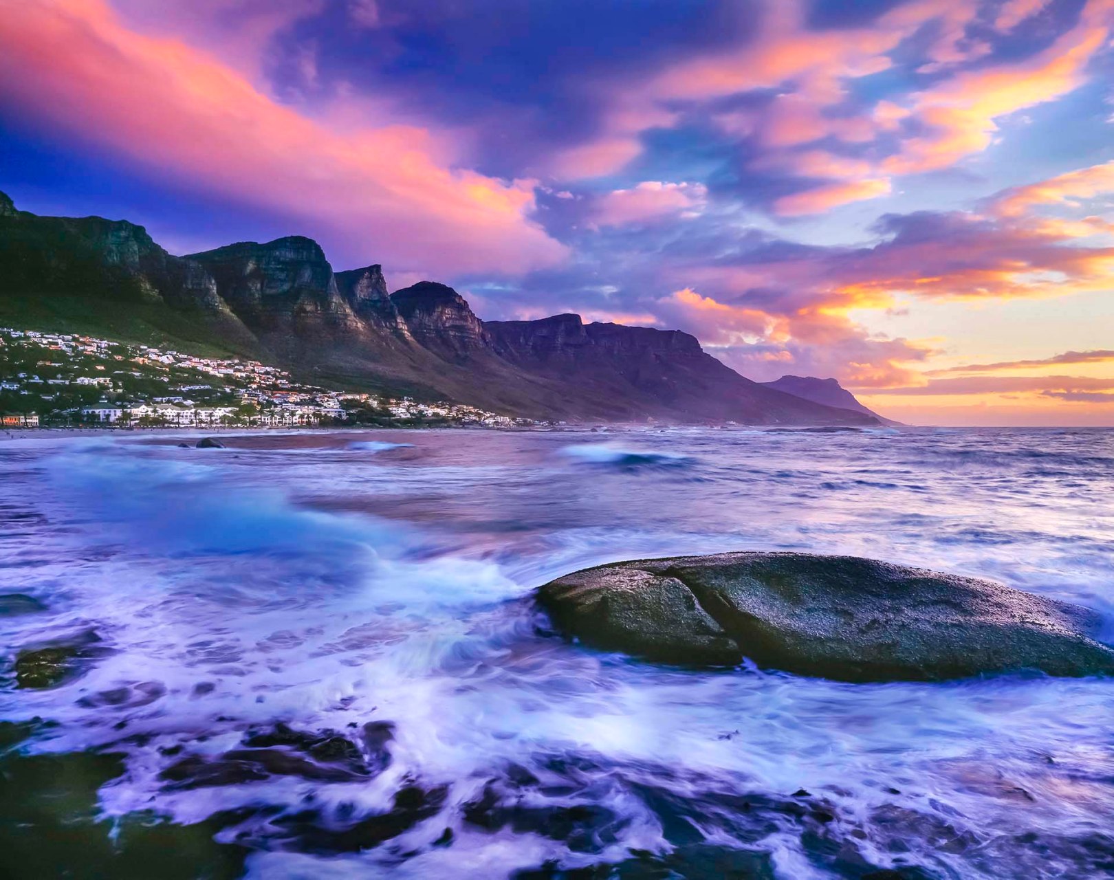 costa di Camps Bay a Città del Capo, in Sudafrica, con la catena montuosa dei Dodici Apostoli sullo sfondo.