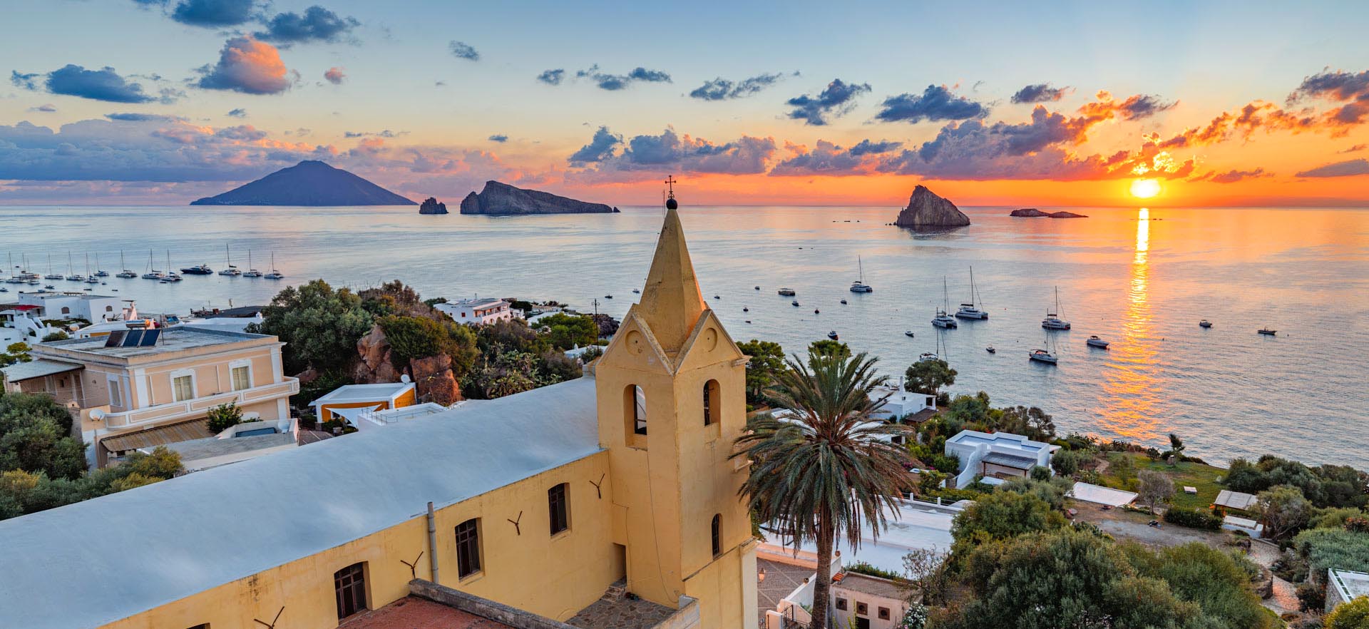 Alba a Panarea: La Chiesa di San Pietro, gli Isolotti e lo Stromboli all’Orizzonte