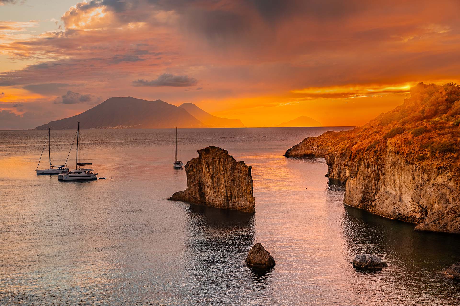 Lo Scoglio Brigantino nella baia di Cala Junco a Panarea, con vista su Salina e Filicudi